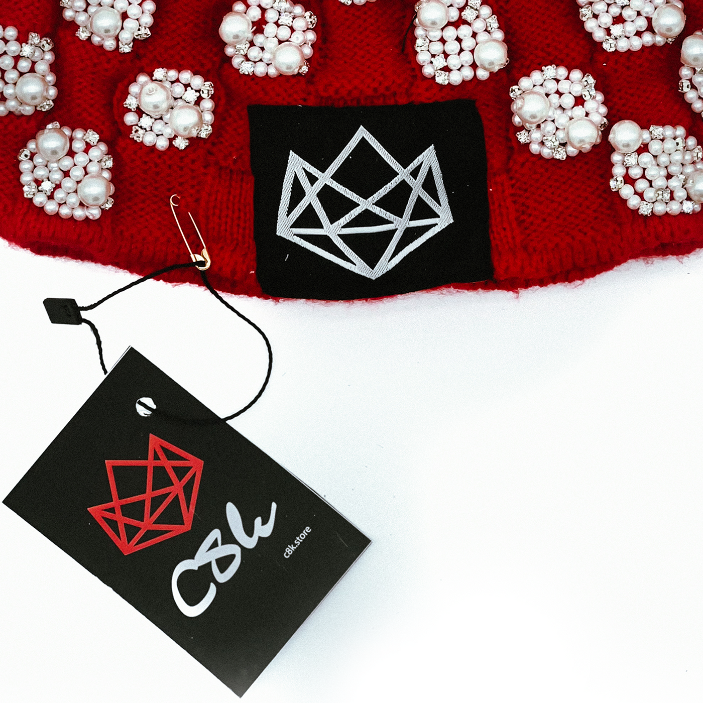 C8K luxury Skully with pearl embellishments and a black tag with geometric design and 'C8K' logo.
